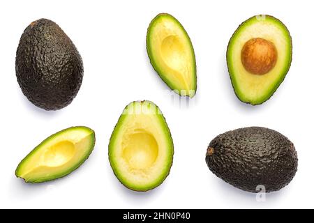 Intero e tagliato nero avocado Hass isolato su sfondo bianco. Foto Stock