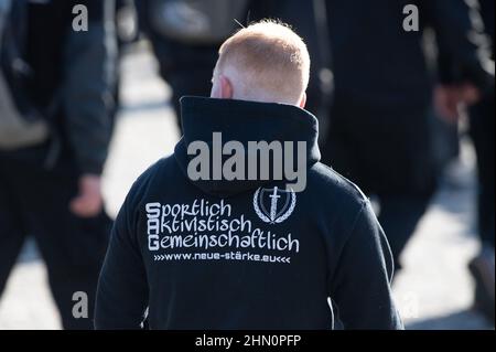 Dresda, Germania. 13th Feb 2022. Un partecipante a un raduno di neo-nazisti indossa un maglione con l'iscrizione 'portlich Aktivistisch Gemeinschaftlich'. La processione, dichiarata una marcia silenziosa, è stata accompagnata da diverse controdimostrazioni. Credit: Kahnert/dpa-Zentralbild/dpa/Alamy Live News Foto Stock