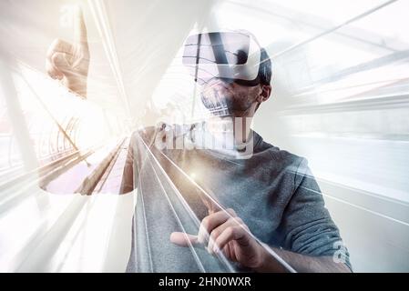 Giovane uomo che indossa occhiali/occhiali per realtà virtuale VR Foto Stock