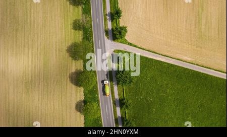 Vista aerea della strada a due corsie attraverso la campagna e campi coltivati con auto. Spazio per foto con drone e copia del testo Foto Stock