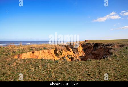 Buco di colatura nelle scogliere causato da runoff d'acqua e infiltrazioni sulla costa nord del Norfolk a Happisburgh, Norfolk, Inghilterra, Regno Unito. Foto Stock