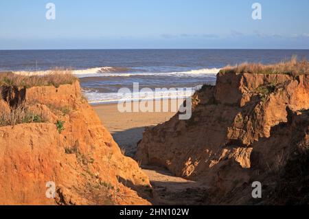 Si rompe nelle scogliere a causa di un eccesso d'acqua dalla terra alla spiaggia sulla costa nord del Norfolk a Happisburgh, Norfolk, Inghilterra, Regno Unito. Foto Stock