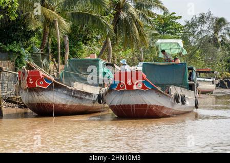 Le tradizionali barche da carico in legno sul fiume Mekong sono dipinte con occhi rossi per portare fortuna, provincia di Vinh Long, Delta del Mekong, Vietnam del Sud Foto Stock