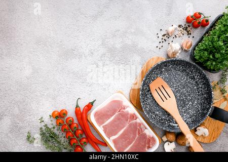 Padella in marmo nero con prodotti su sfondo grigio del tavolo, vista dall'alto Foto Stock