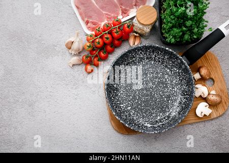 Padella in marmo nero con prodotti su sfondo grigio del tavolo, vista dall'alto Foto Stock