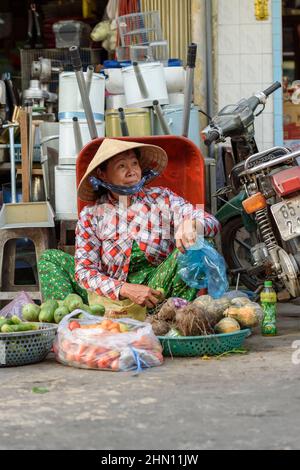 Una donna vietnamita matura vende i suoi prodotti al trafficato mercato alimentare mattutino a Cai Rang, vicino a Can Tho, Delta del Mekong, Vietnam del Sud Foto Stock