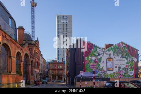 La facciata di Salmon Street dell'ex mercato del pesce all'ingrosso di Manchester, costruzione del blocco torre Back Turner Street e un murale pubblicitario da M. Foto Stock
