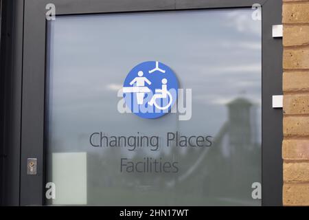 Il cartello sulla porta di un bagno Changing Places al lago Willen a Milton Keynes. Foto Stock