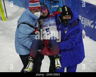 Zhangjiakou, Cina. 13th Feb 2022. I pullman portano la Norvegia Ingrid Landmark Tandrevold fuori dalla zona di arrivo dopo che è crollata dopo la donna Biathlon 10km Pursuit alle Olimpiadi invernali di Pechino 2022 a Zhangjiakou, Cina Domenica, 13 febbraio 2022. Foto di Bob strong/UPI . Credit: UPI/Alamy Live News Foto Stock