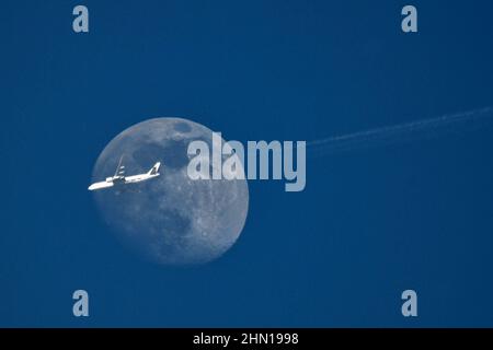 Mnichovo Hradiste, Repubblica Ceca. 13th Feb 2022. Un aereo BOEING 777 DAALJ dall'India a Lipsia in Germania vola oltre la luna in declino nel cielo blu dell'autunno sopra la Repubblica Ceca. Il traffico aereo tornerà presto in altri aeroporti regionali, dopo che i voli sono stati limitati per la maggior parte dell'anno come parte degli sforzi del governo per controllare la pandemia COVID-19. (Credit Image: © Slavek Ruta/ZUMA Press Wire) Foto Stock