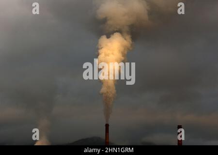 Camini industriali pesanti che producono fumo e fuoco. Illustrazione dell'inquinamento atmosferico e danni agli organi respiratori. Riscaldamento globale e industria del carbone Foto Stock