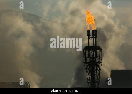 Camini industriali pesanti che producono fumo e fuoco. Illustrazione dell'inquinamento atmosferico e danni agli organi respiratori. Riscaldamento globale e industria del carbone Foto Stock
