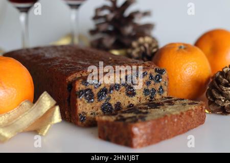 Fette di torta di frutta bollita. Una torta di frutta facile senza alcool. Preparato con frutta secca bollita in succo d'arancia. Scatto su sfondo bianco insieme al rosso Foto Stock