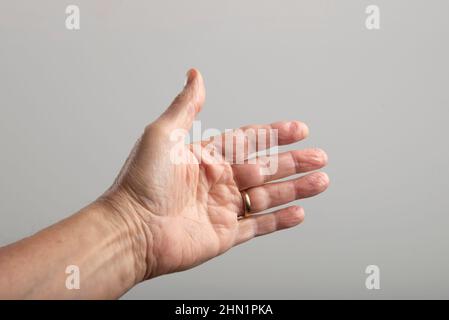 palma della mano sinistra di un uomo con anello di nozze Foto Stock