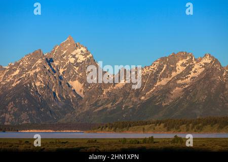 La luce del mattino presto sopra il lago Jackson e la catena montuosa Grand Teton, il parco nazionale Grand Teton NP, maggio, Wyoming, il parco nazionale Grand Teton, Stati Uniti Foto Stock