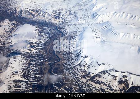 Islanda, vista aerea dall'aereo, che mostra montagne innevate, fiume e valle, a maggio Foto Stock