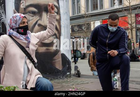 Sostenitori BLM maschi e femmine su un ginocchio Foto Stock