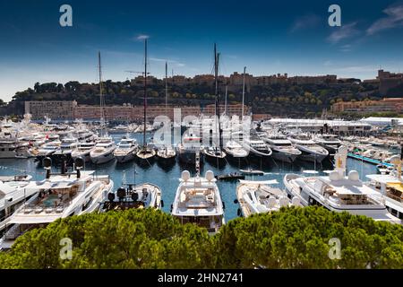 Molti grandi yacht sono nel porto Hercule di Monaco in giornata di sole, Monte Carlo, molte piccole barche sono sullo sfondo, interni di motoscafo, raffreddamento Foto Stock