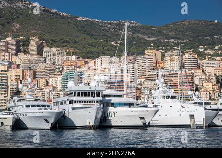 Un sacco di grandi yacht sono nel porto di Monaco al giorno di sole, megayachts sono ormeggiati nel porto turistico, è uno yacht show, Monte Carlo, immobiliare case è on Foto Stock