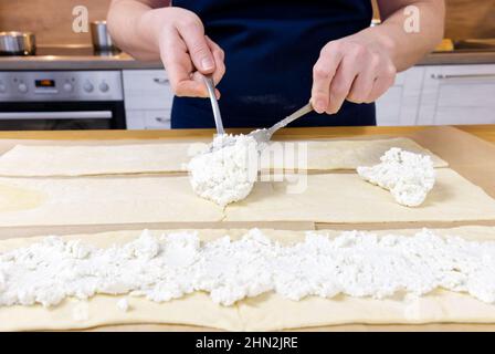 lo chef mette il formaggio caserario sulla pasta. Torta di Natale saporita a forma di un processo di fabbricazione della corona. Foto Stock