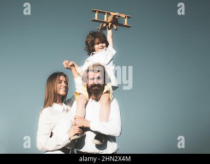 Famiglia felice all'aperto, bambino con aeroplano giocattolo. Concetto di viaggio, vacanza e libertà. Buon viaggio con la famiglia. La gente sogna di viaggiare. Estate Foto Stock