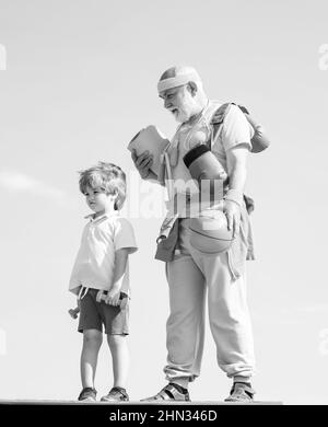 Gioioso uomo vecchio e ragazzo carino praticare sport e stile di vita sano su sfondo cielo. Riabilitazione. Amo lo sport. Sport per poco Foto Stock