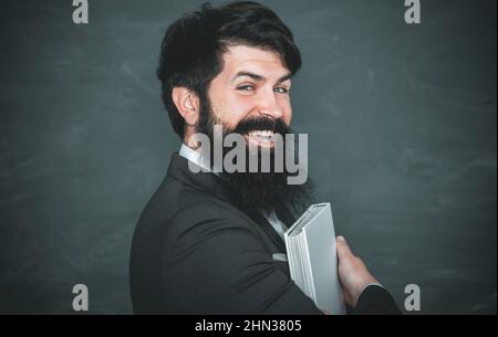 Giornata degli insegnanti. Professore in classe su sfondo lavagna. Spazio di copia della lavagna. Foto Stock