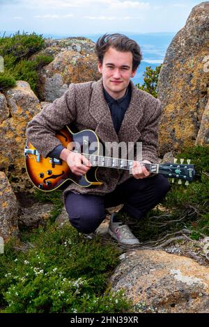 Il giovane musicista e chitarrista jazz della Tasmania Eli Davies ha fotografato sulla vetta del Monte Wellington a Hobart Foto Stock