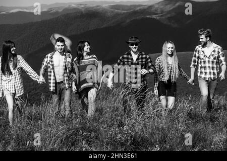 Gruppo di giovani che camminano sulla natura estiva all'aperto. Gruppi di amici che si rilassano si godono all'aperto. Foto Stock