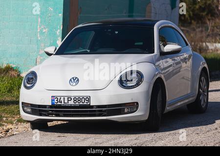 Side, Turchia -27 gennaio 2022: Auto bianca Volkswagen Beetle sullo sfondo di una strada della città, vista frontale. Foto Stock