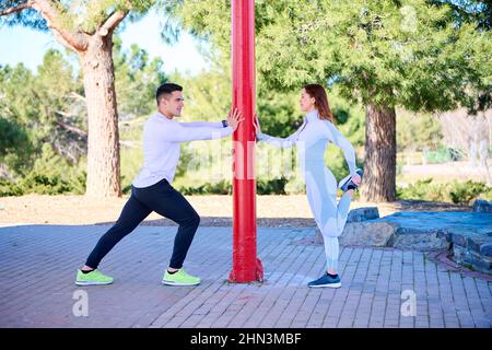 Giovane uomo e donna che si allenano nella palestra all'aperto Foto Stock