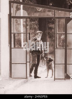 Foto d'epoca della crisi di Berlino del 1961: Costruire il Muro. Con Alert Watchdog e Machine Pistol, questo membro della polizia popolare osserva Activit Foto Stock