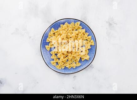 farfalle in piatto blu. pasta tradizionale italiana Foto Stock