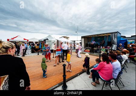 La gente si è riunita al Kilmore Seafood Festival. Comunità di Signore e signori che ballano all'aperto in un villaggio irlandese. Kilmore Quay, Irlanda Foto Stock