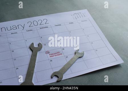 Concetto di manutenzione programmata. Chiave e calendario con testo MANUTENZIONE PROGRAMMATA Foto Stock