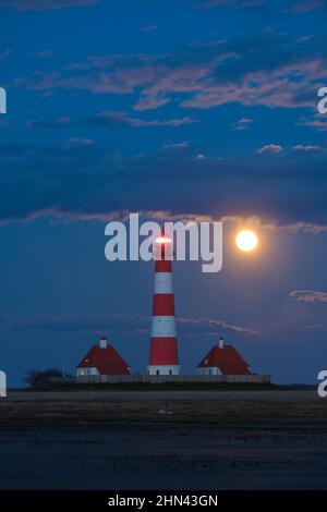 Il faro Westerheversand a luna piena. Penisola di Eiderstedt, Frisia settentrionale, Germania Foto Stock