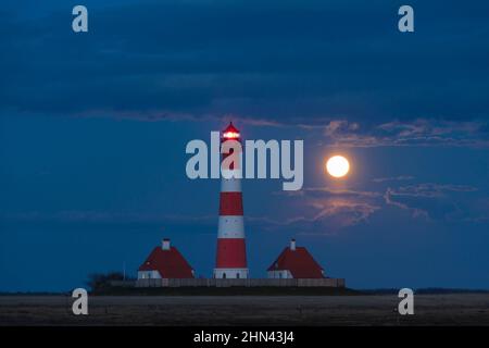 Il faro Westerheversand a luna piena. Penisola di Eiderstedt, Frisia settentrionale, Germania Foto Stock