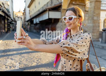 Donna che visita il famoso vecchio ponte, chiamato Ponte Vecchio, a Firenze Foto Stock
