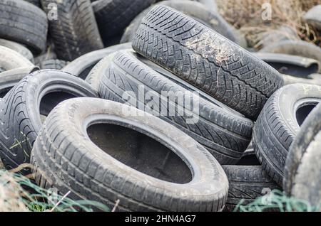 Un cumulo di pneumatici per auto danneggiati, vecchi, scartati per il riciclaggio. Foto Stock