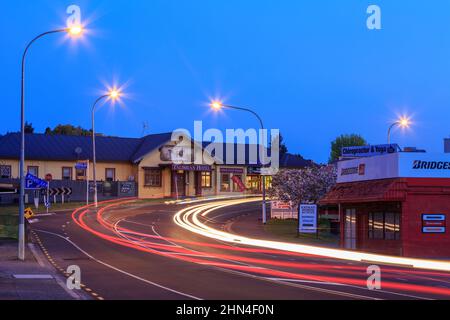 La città di Katikati, Nuova Zelanda, di notte. Sul lato sinistro della strada si trova il Talisman Hotel and Restaurant Foto Stock