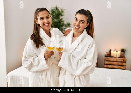 Due donne indossano accappatoio tostando con champagne in piedi al centro di bellezza Foto Stock