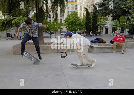 Un giovane skater che registra in video un altro skater in Piazza Las Cortes di Madrid. Foto Stock