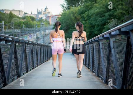 coppia di giovani donne che camminano in abbigliamento sportivo Foto Stock