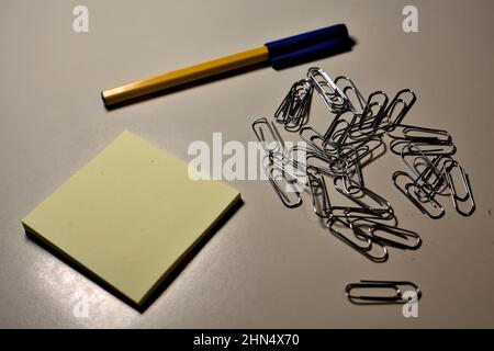 Penna con blocco per appunti e clip su una scrivania Foto Stock