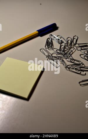 Penna con blocco per appunti e clip su una scrivania Foto Stock