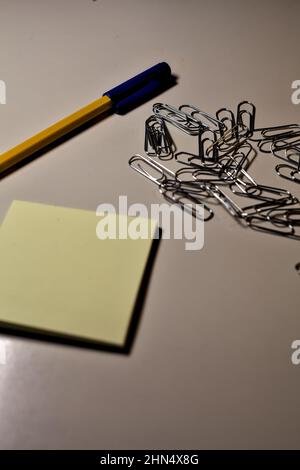 Penna con blocco per appunti e clip su una scrivania Foto Stock