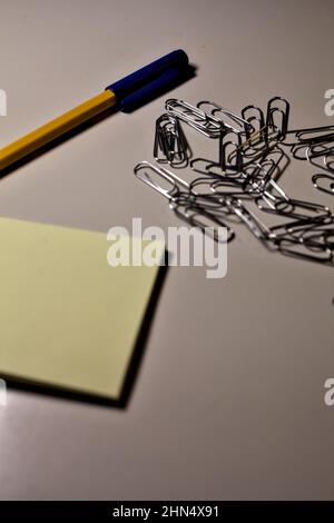 Penna con blocco per appunti e clip su una scrivania Foto Stock