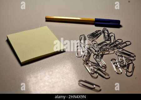 Penna con blocco per appunti e clip su una scrivania Foto Stock