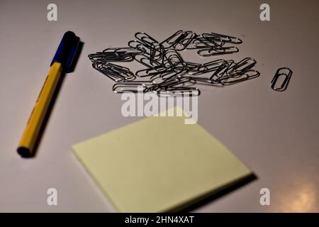 Penna con blocco per appunti e clip su una scrivania Foto Stock