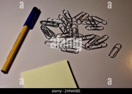 Penna con blocco per appunti e clip su una scrivania Foto Stock
